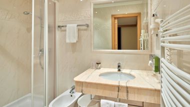 Das Badezimmer mit Dusche, Waschbecken und Bidet