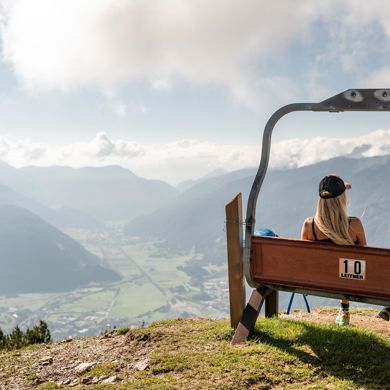 Zwei Frauen auf einer Bank mit Aussicht auf das Tal und die Berge