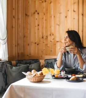 Una donna fa colazione nella sala da pranzo