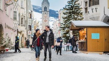 A couple is visiting the christmas market in Vipiteno
