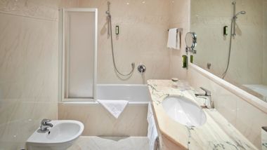 Das Badezimmer mit Badewanne, Waschbecken und Bidet