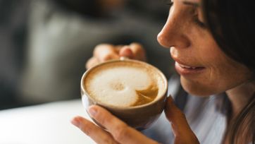 Eine Frau trinkt einen Cappuccino
