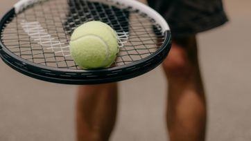 Ein Mann mit Tennisschläger und Tennisball