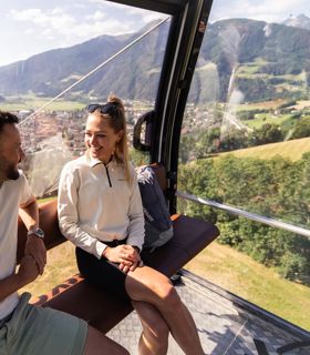 Two people are riding a cable car