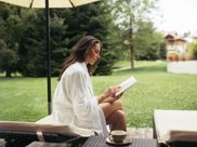 Eine Frau liest ein Buch im Garten