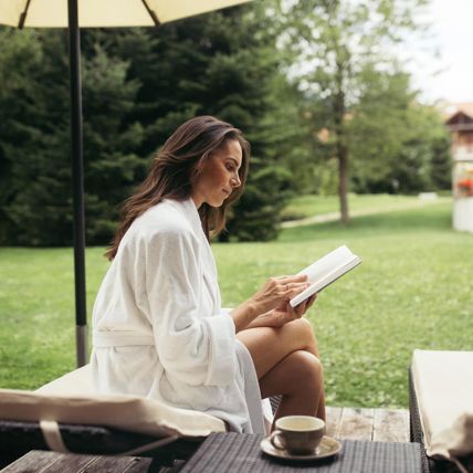 Eine Frau liest ein Buch im Garten