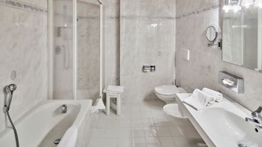 Das Badezimmer mit Badewanne und Dusche