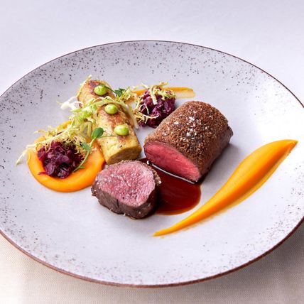 Rinderfilet mit Gemüse, Rösti und Sauce, garniert mit frischen Kräutern und Karottenpüree.